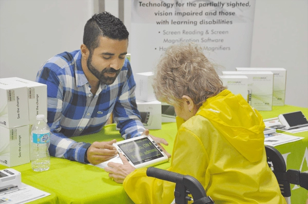 jad nohra managing director introducting zoomax snow 7 hd plus to a visitor in the cnib simcoe muskoka 2017