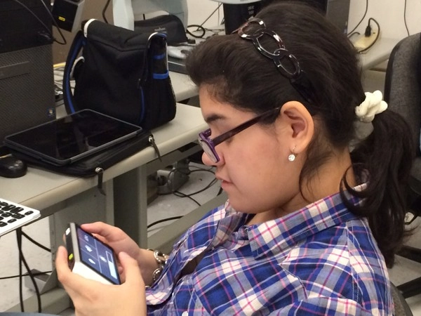 student of the new york institute for special educationnyise is checking the adjustment panel of zoomax handheld video magnifier m5