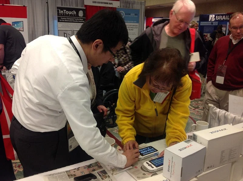 people test zoomax handheld video magnifier at exhibition csun 2013
