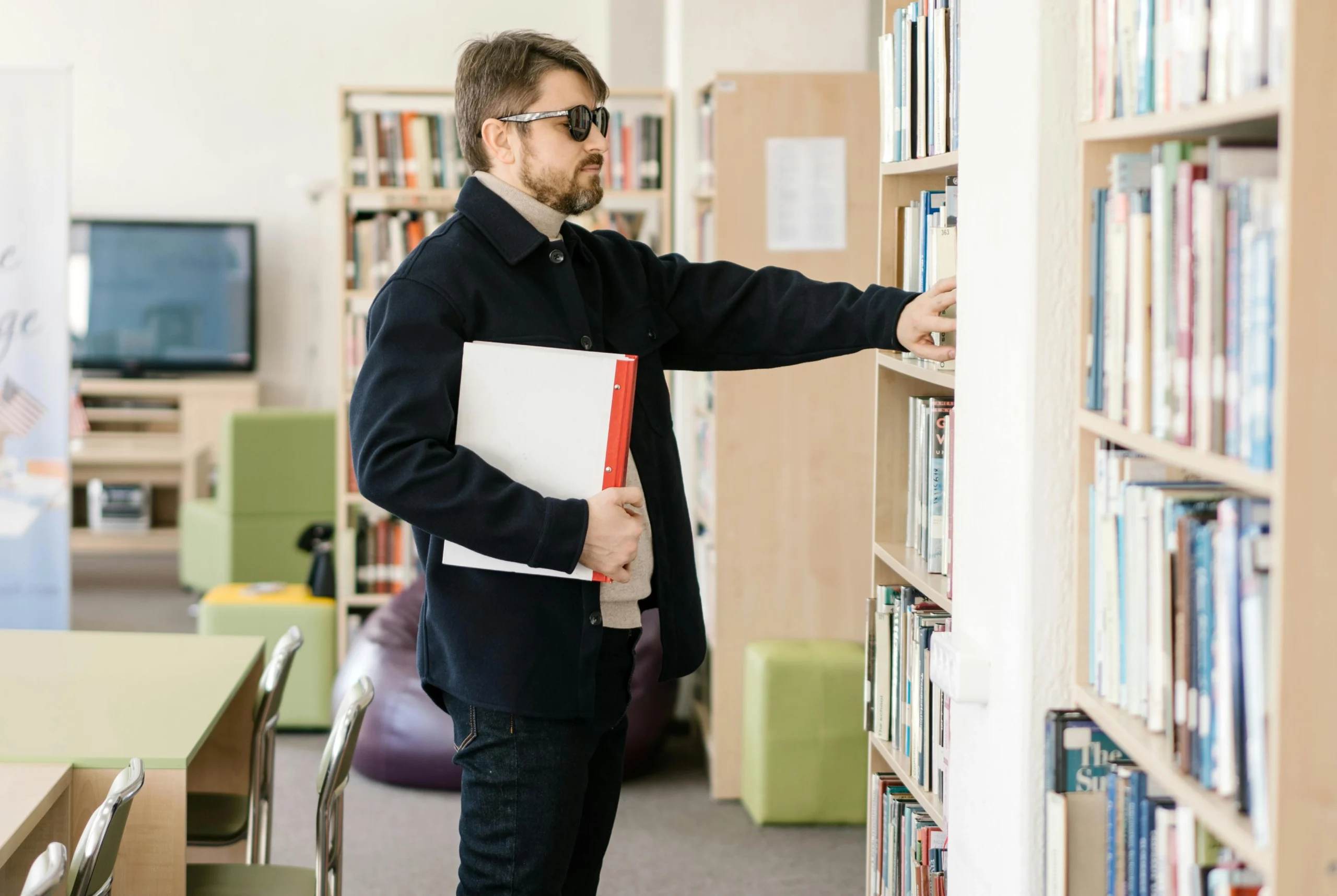 a visually impaired reader closely browsing books at an accessible public library